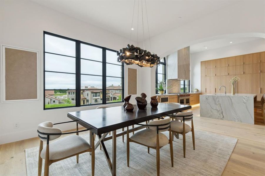 Dining space featuring plenty of natural light, white oak wood floors, a designer lighting, and recessed lighting Dining space featuring plenty of natural light, white oak wood floors, a designer lighting, and recessed lighting