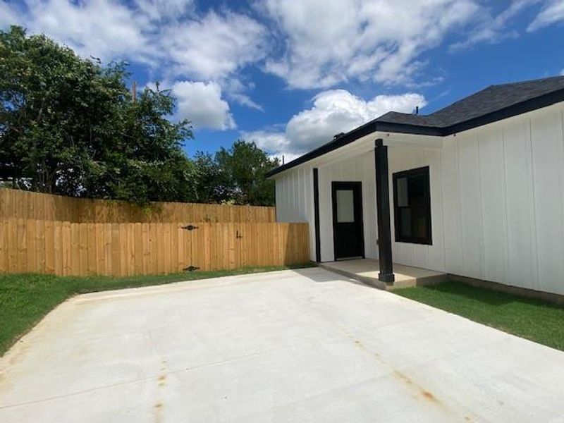 A private backyard oasis features a fresh concrete pad, lush grass, and secure wooden fencing. A private backyard oasis features a fresh concrete pad, lush grass, and secure wooden fencing.