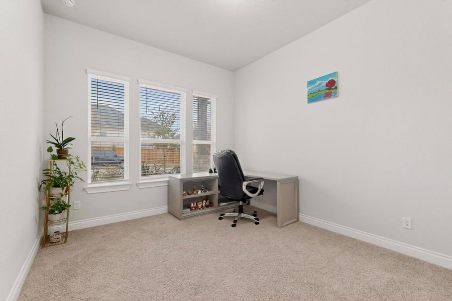 Home office featuring light carpet and baseboards