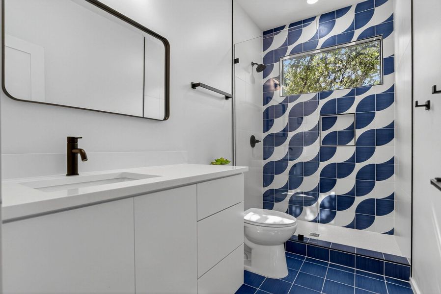 Full bath featuring dark tile patterned flooring, vanity, and a shower with shower curtain