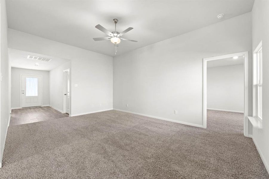 Carpeted empty room with ceiling fan