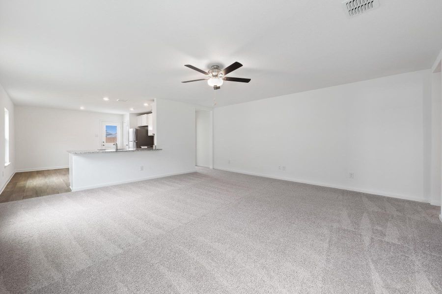 An open floorplan seamlessly connects the well-lit living area with the modern kitchen.