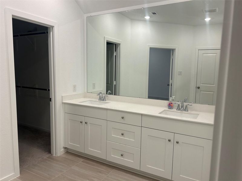 The double sink vanity features a full wall of mirrors and double sinks. The double sink vanity features a full wall of mirrors and double sinks.