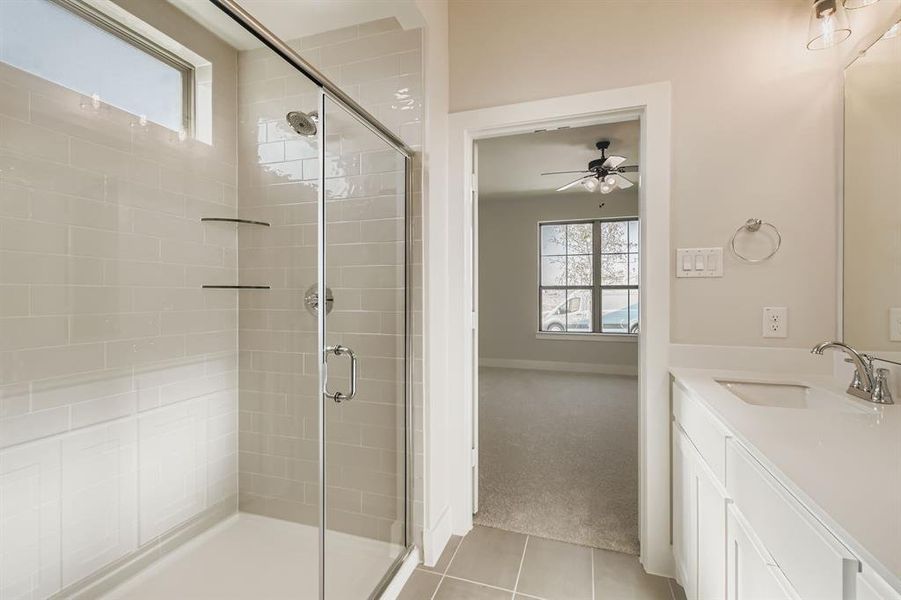 Bathroom featuring plenty of natural light, a shower stall, and vanity