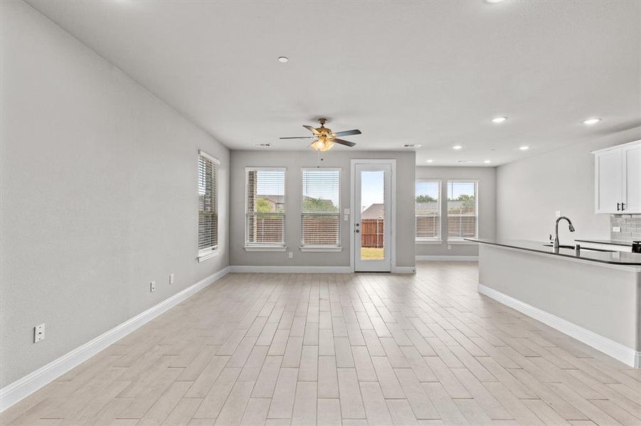 Unfurnished living room featuring ceiling fan and light wood-type flooring