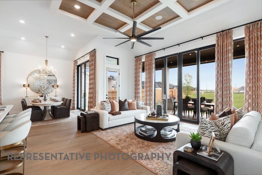 Living room with beam ceiling, ceiling fan with notable chandelier, recessed lighting, wood finished floors, and coffered ceiling