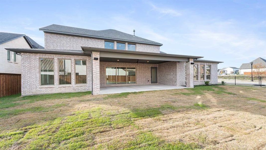 Back of property featuring a yard and a patio area