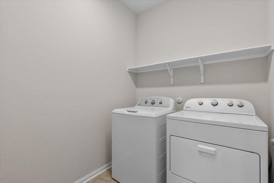 Functional workspace features built-in shelving and ample room for laundry tasks.