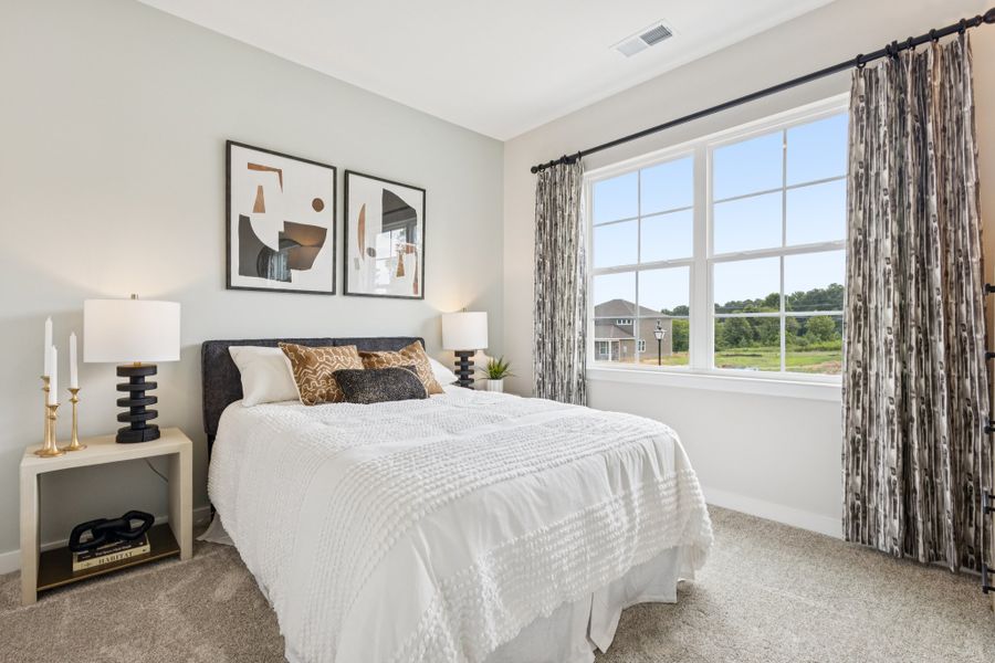 A bedroom with a large window.