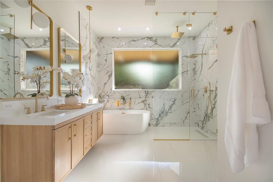 Bathroom featuring a marble finish shower, a freestanding bath, stone wall, double vanity, and tile walls Bathroom featuring a marble finish shower, a freestanding bath, stone wall, double vanity, and tile walls