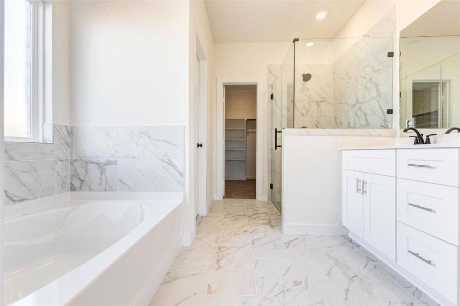 Spa-inspired bath with dual sinks, soaking tub, separate shower, and modern finishes.