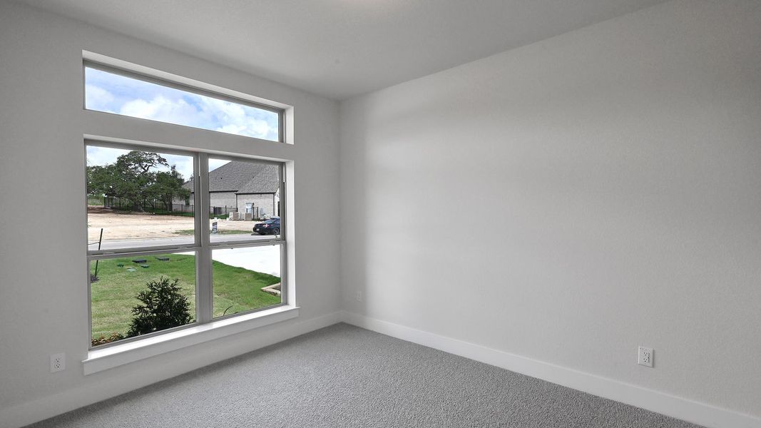 Carpeted spare room featuring baseboards Carpeted spare room featuring baseboards