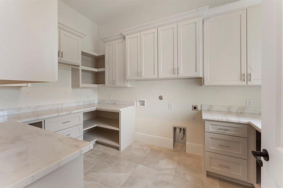 This is your laundry room! Say What? There is also a sink to the right with gorgeous views through the window. Cream shaker-style cabinetry, Quartz countertops, neutral color palette with ample storage space.