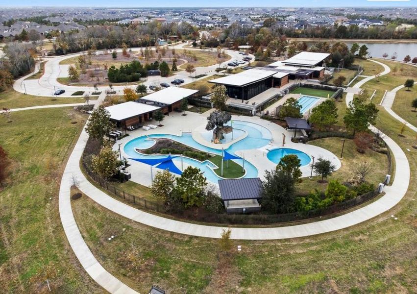 Beautiful community amenity center with pools, gathering spaces, and scenic park surroundings.