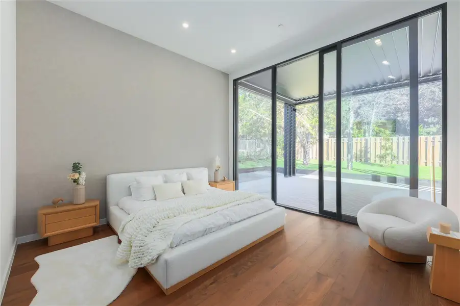 Floor-to-ceiling glass doors open to a tranquil private yard, offering seamless indoor-outdoor living.