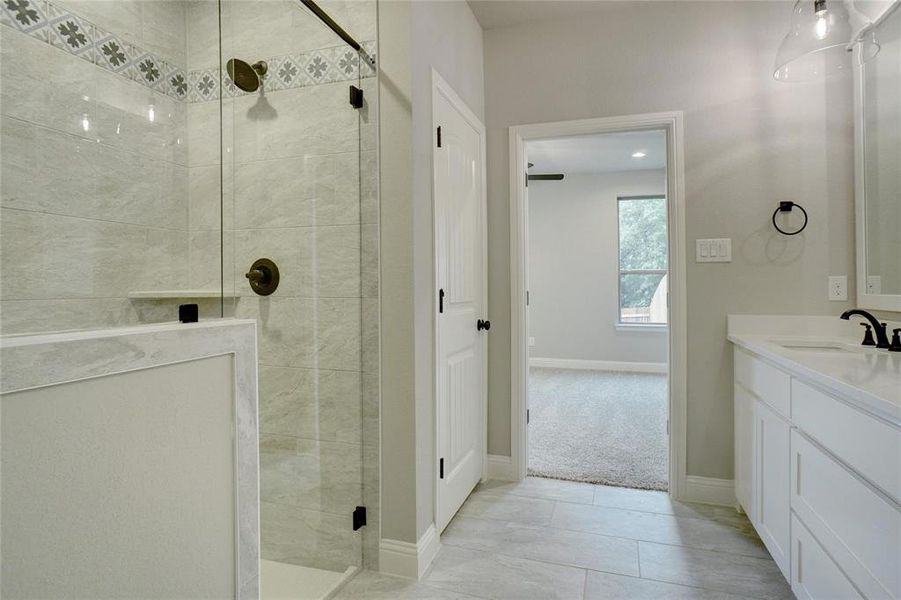 Bathroom featuring a stall shower, vanity, and light tile patterned floors