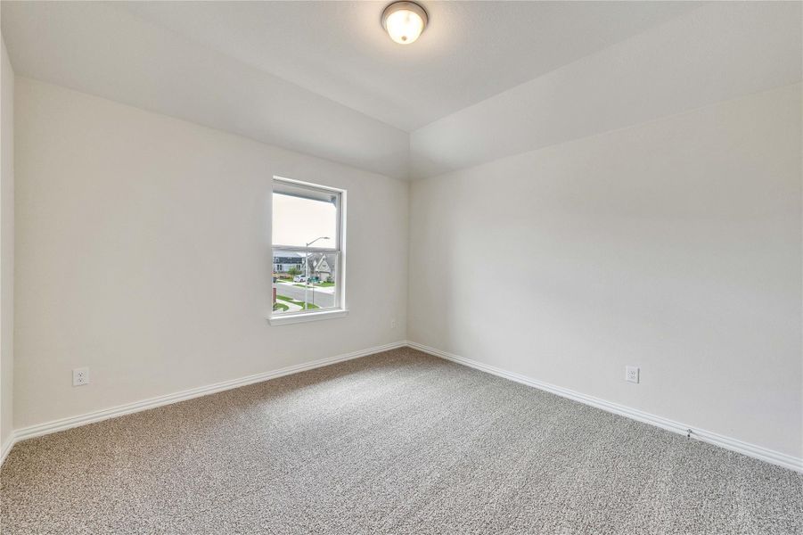 Carpeted spare room featuring baseboards and vaulted ceiling Carpeted spare room featuring baseboards and vaulted ceiling
