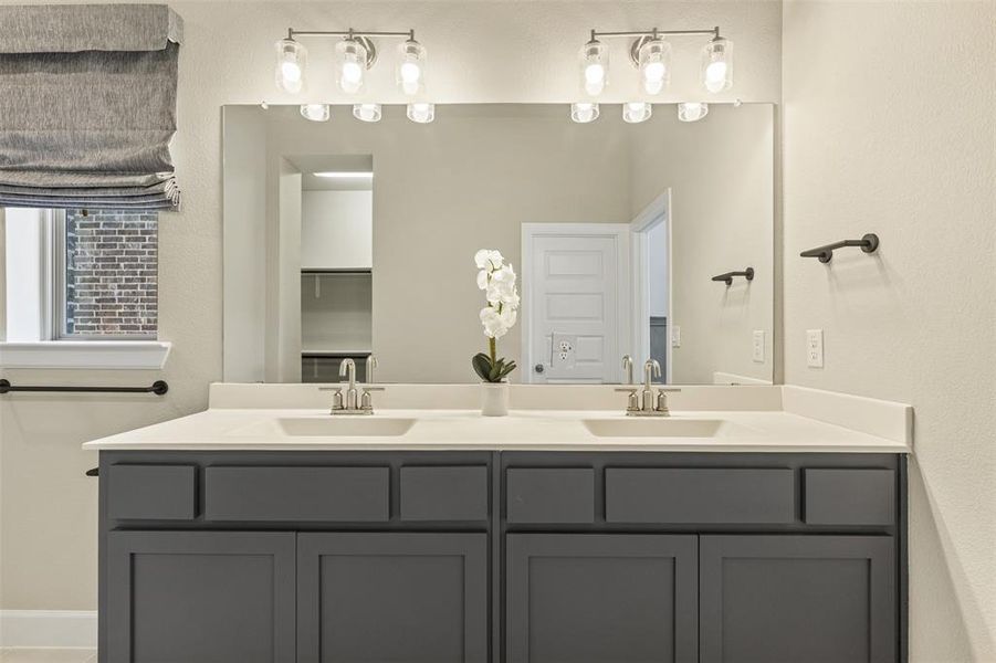 Full bath featuring double vanity and a sink