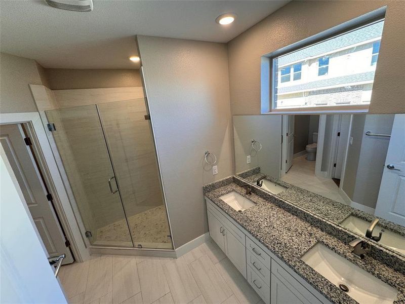 Bathroom with vanity, an enclosed shower, and toilet