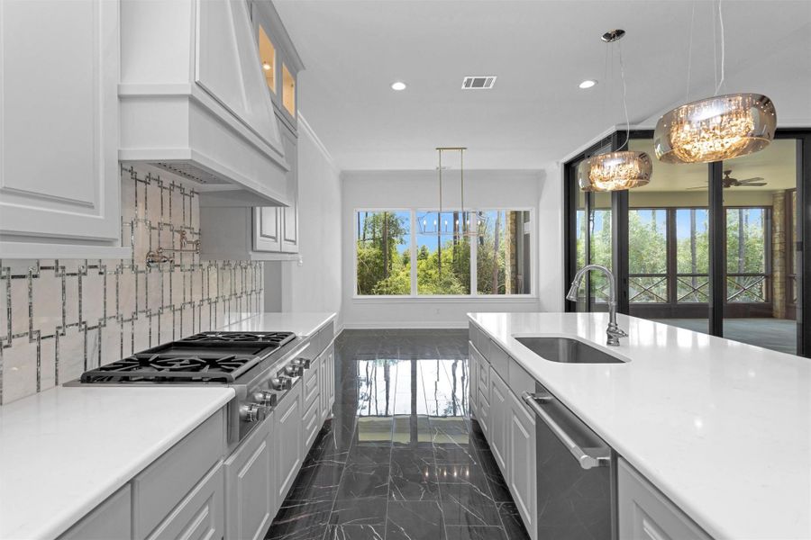 Enjoy forest views while cooking or entertaining in this stunning kitchen, where designer finishes meet natural light and indoor-outdoor harmony through walls of windows and glass doors. Enjoy forest views while cooking or entertaining in this stunning kitchen, where designer finishes meet natural light and indoor-outdoor harmony through walls of windows and glass doors.