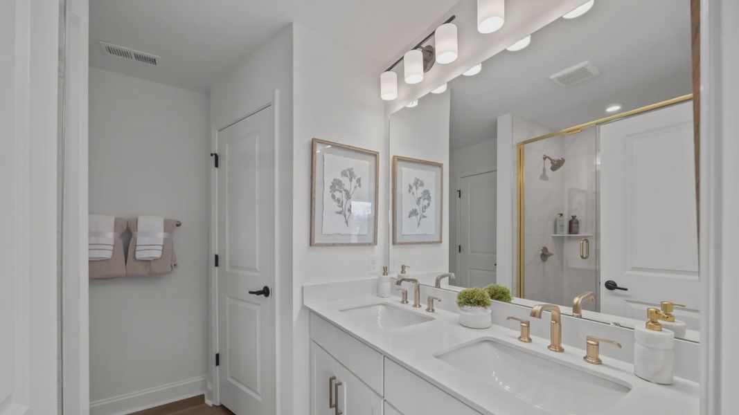 The Rochester Plan by DRB homes primary bathroom in solid white with gold fixtures in Charlotte, NC.