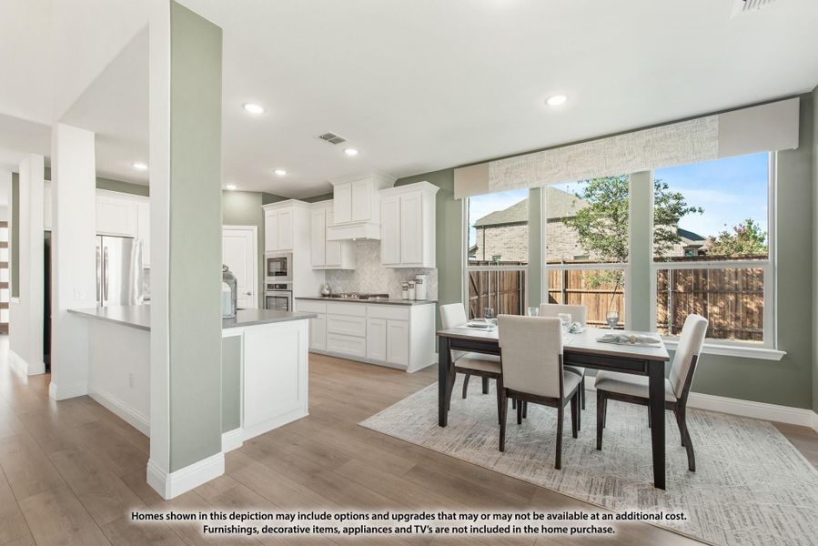 Open dining area with dark wood table and four chairs, adjacent to white kitchen with hardwood floors and large windows Open dining area with dark wood table and four chairs, adjacent to white kitchen with hardwood floors and large windows