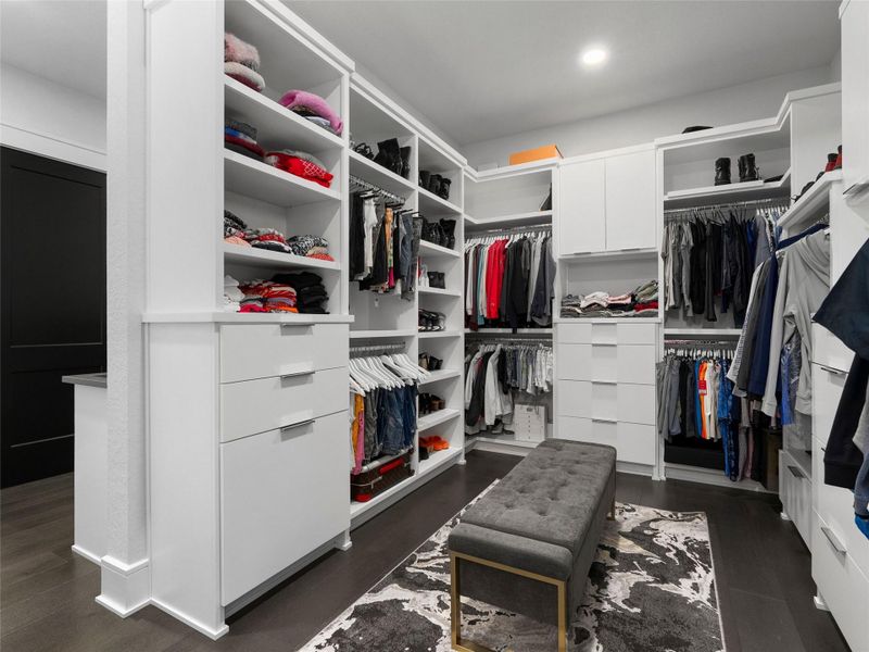 Custom walk in closet featuring dark wood-style flooring