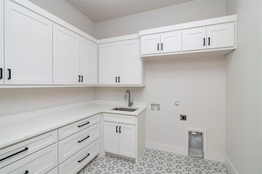 Washroom featuring sink, electric dryer hookup, washer hookup, and cabinets