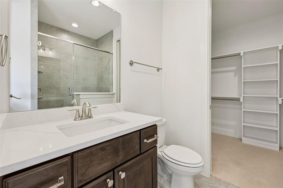 Bathroom featuring a dark wood-finish vanity with a white countertop and undermount sink