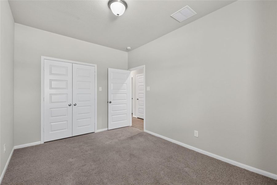 This is a cozy, carpeted room with neutral walls, featuring a closet with double doors. Perfect for a bedroom or home office. This is a cozy, carpeted room with neutral walls, featuring a closet with double doors. Perfect for a bedroom or home office.