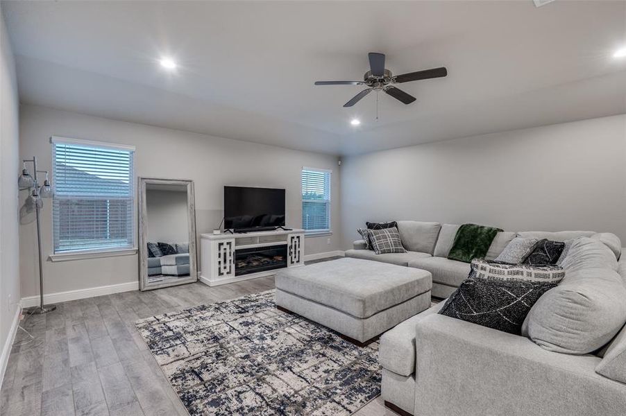 Living room featuring light wood finished floors, ceiling fan, healthy amount of natural light, and recessed lighting