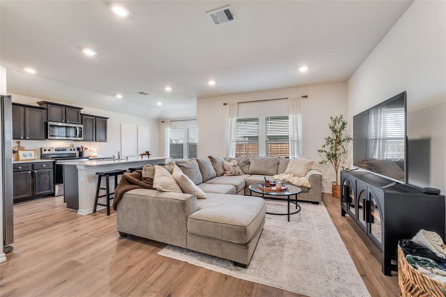 Living area with recessed lighting, healthy amount of natural light, and light wood-type flooring
