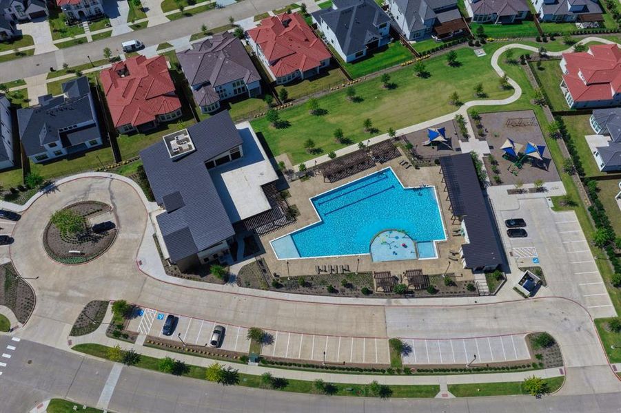 Community recreation area featuring a large swimming pool, expansive pool deck with pergolas, and a designated children's play area with shade structures Community recreation area featuring a large swimming pool, expansive pool deck with pergolas, and a designated children's play area with shade structures