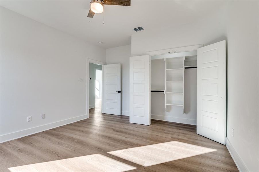 Unfurnished bedroom featuring light wood finished floors, ceiling fan, and a closet
