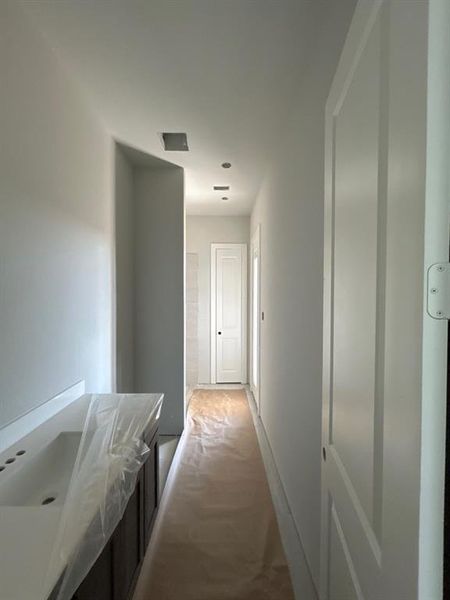 Hall with light carpet and baseboards