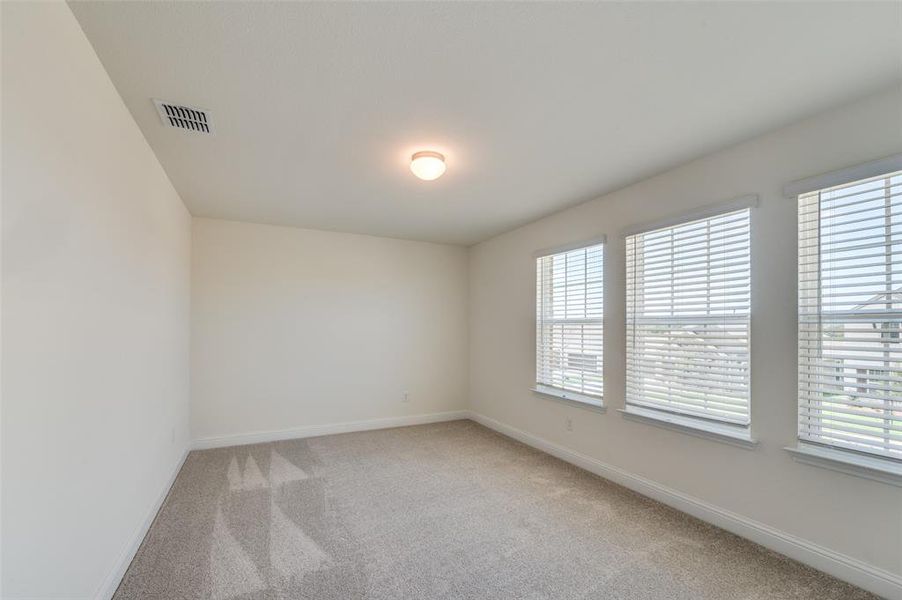 Empty room featuring light colored carpet and baseboards