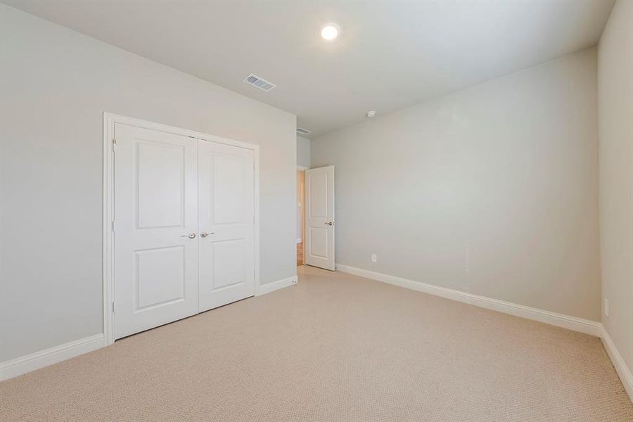 Unfurnished bedroom with carpet, a closet, and recessed lighting Unfurnished bedroom with carpet, a closet, and recessed lighting