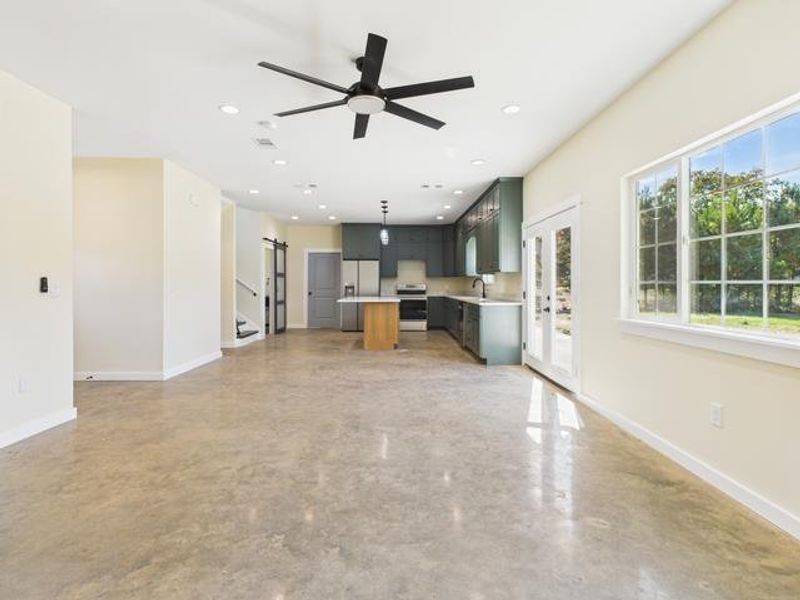 Unfurnished living room with french doors, concrete floors, a ceiling fan, and recessed lighting