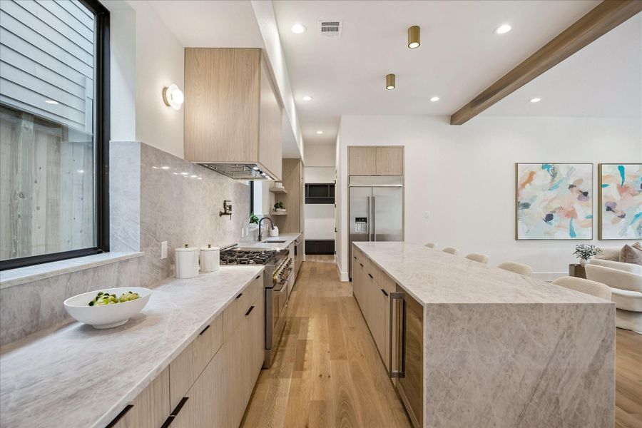 Kitchen is open to the living room and features designer lighting fixtures and exposed wood beams. Kitchen is open to the living room and features designer lighting fixtures and exposed wood beams.