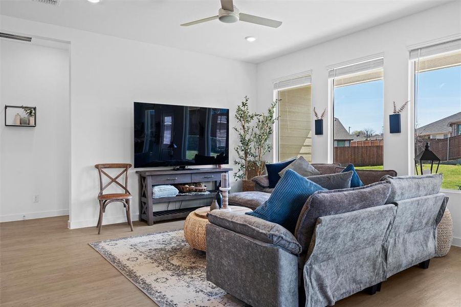 Living area featuring plenty of natural light, a ceiling fan, light wood finished floors, and recessed lighting Living area featuring plenty of natural light, a ceiling fan, light wood finished floors, and recessed lighting