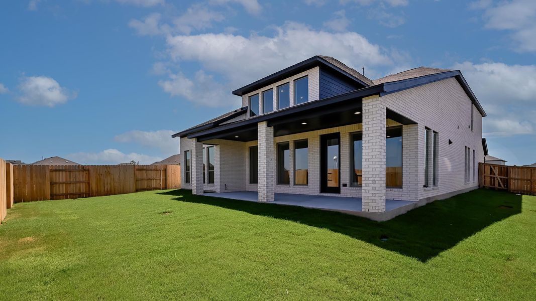 Rear view of property with a patio, a fenced backyard, and brick siding
