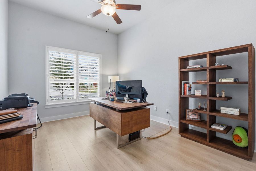 Office space with light wood finished floors and ceiling fan