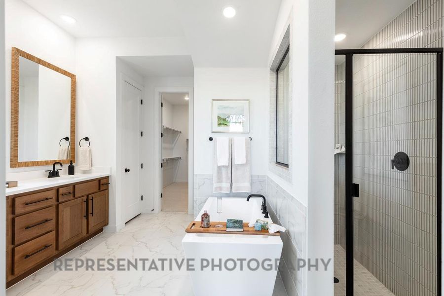 Full bath featuring a stall shower, a freestanding tub, vanity, marble finish floor, and recessed lighting