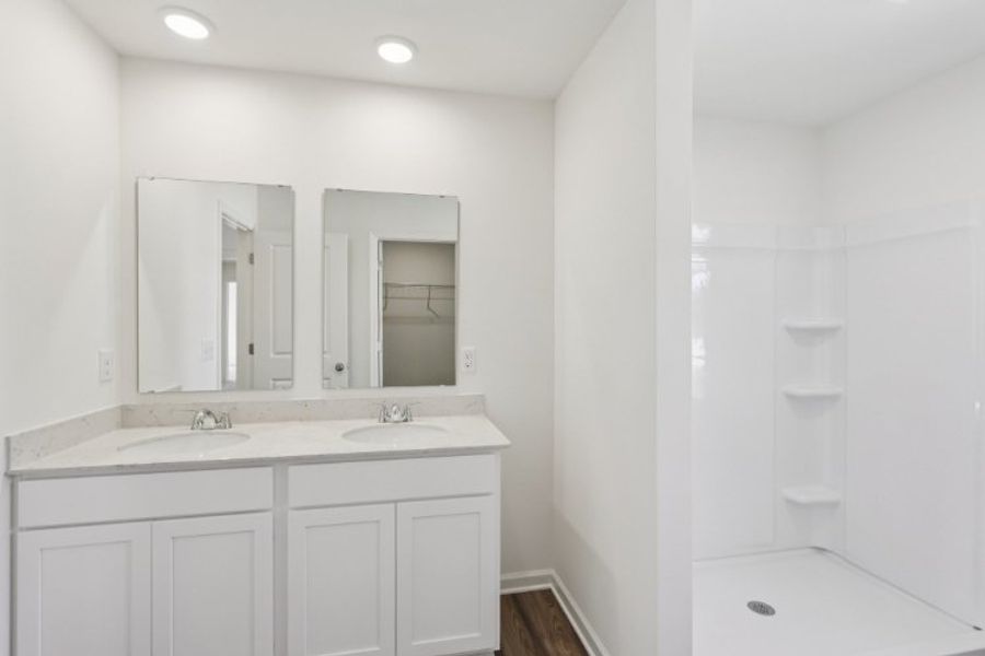 A bathroom with white cabinets.