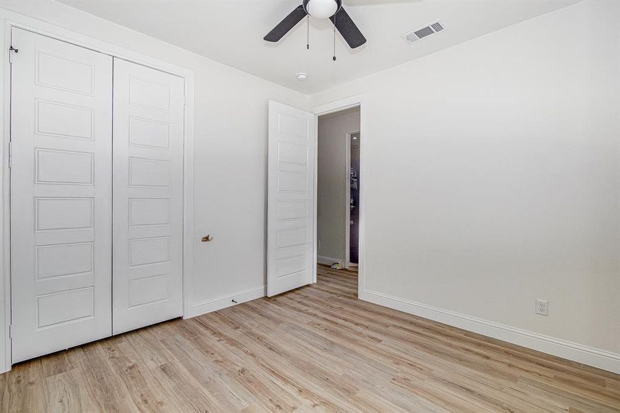 bedroom featuring light wood finished floors, a closet, and ceiling fan
