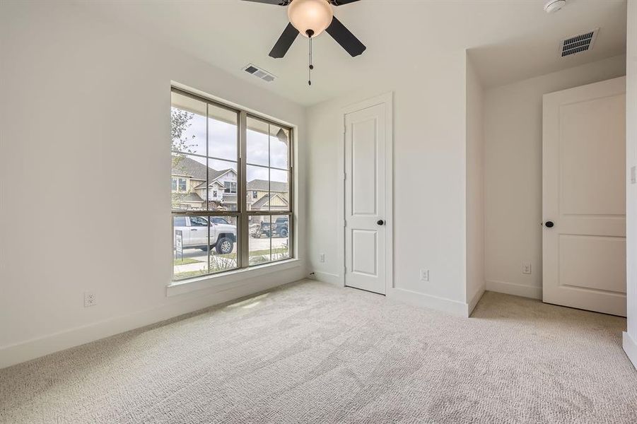 Unfurnished bedroom with carpet and a ceiling fan Unfurnished bedroom with carpet and a ceiling fan