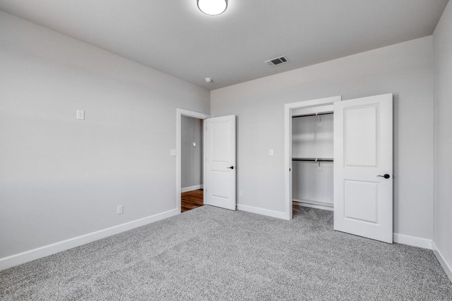 Unfurnished bedroom with carpet, baseboards, and a closet