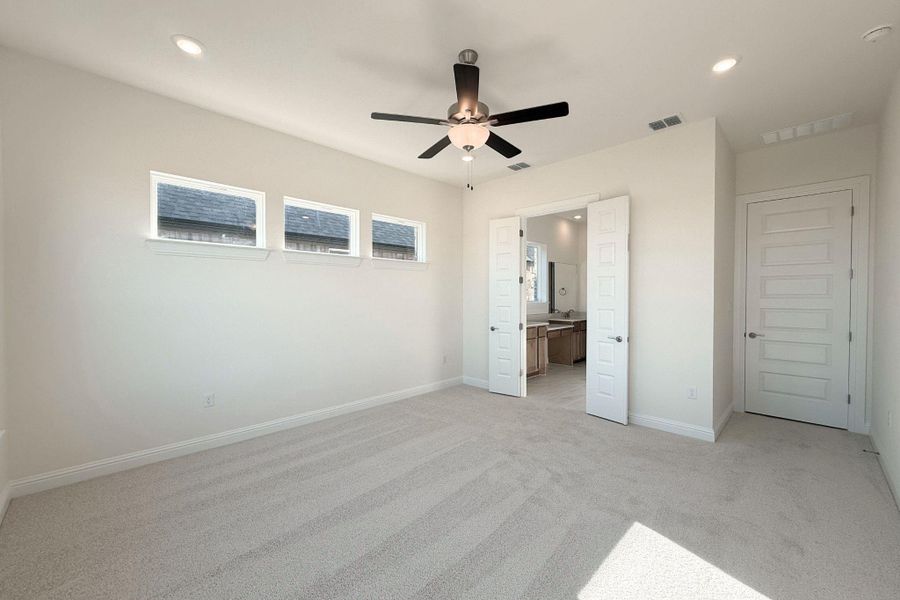 Unfurnished bedroom with recessed lighting, light colored carpet, a ceiling fan, and ensuite bath