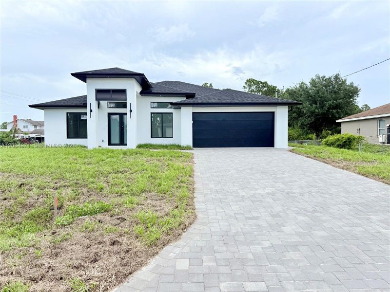 Front exterior of a new home in , Lehigh Acres, FL, highlighting curb appeal (Image 24).