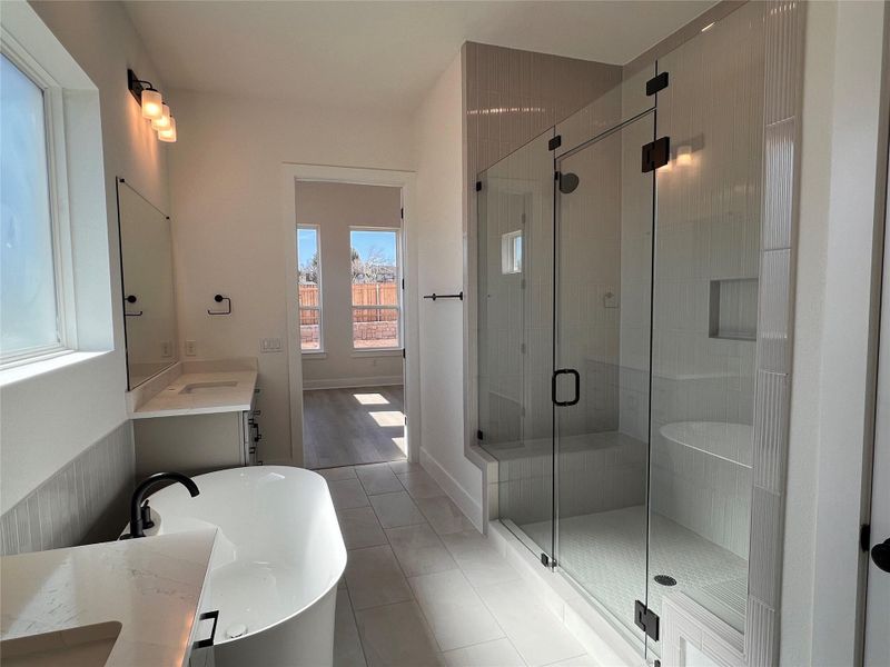 Bathroom featuring a soaking tub, vanity, a stall shower, and light tile patterned floors